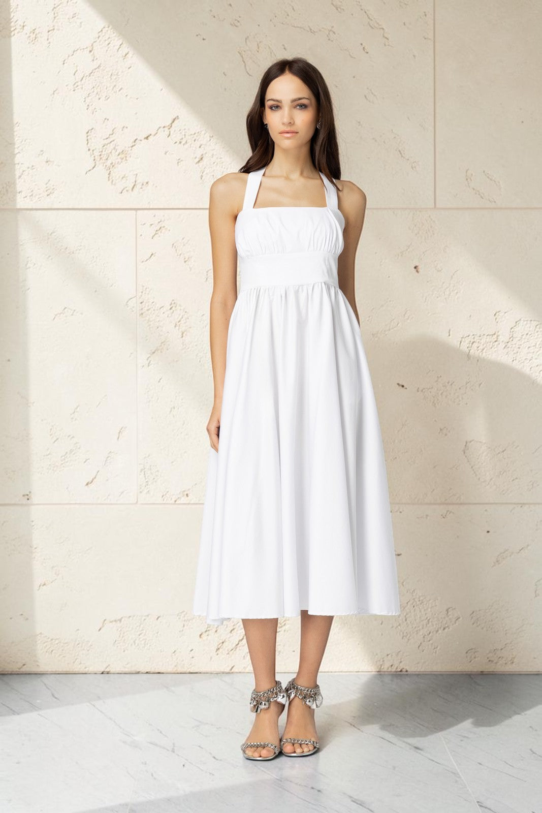 artekozio weißes Midikleid mit Neckholder-Trägern und ausgestelltem Rock an einem Model vor grauem Hintergrund
